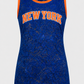 A sleeveless New York Knicks basketball jersey dress featuring a royal blue lace overlay with a sheer mesh base, orange trim, and 'NEW YORK' printed in orange across the chest.