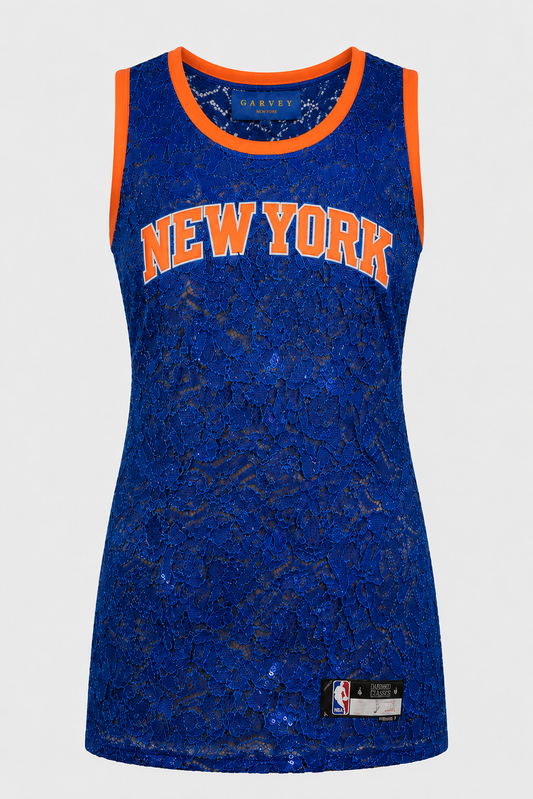 A sleeveless New York Knicks basketball jersey dress featuring a royal blue lace overlay with a sheer mesh base, orange trim, and 'NEW YORK' printed in orange across the chest.