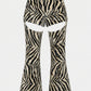 Zebra-print flared pants with large cutout details at the upper thighs, shown against a plain light gray background.