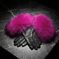 Black gloves with bright pink fur cuffs on a dark textured surface