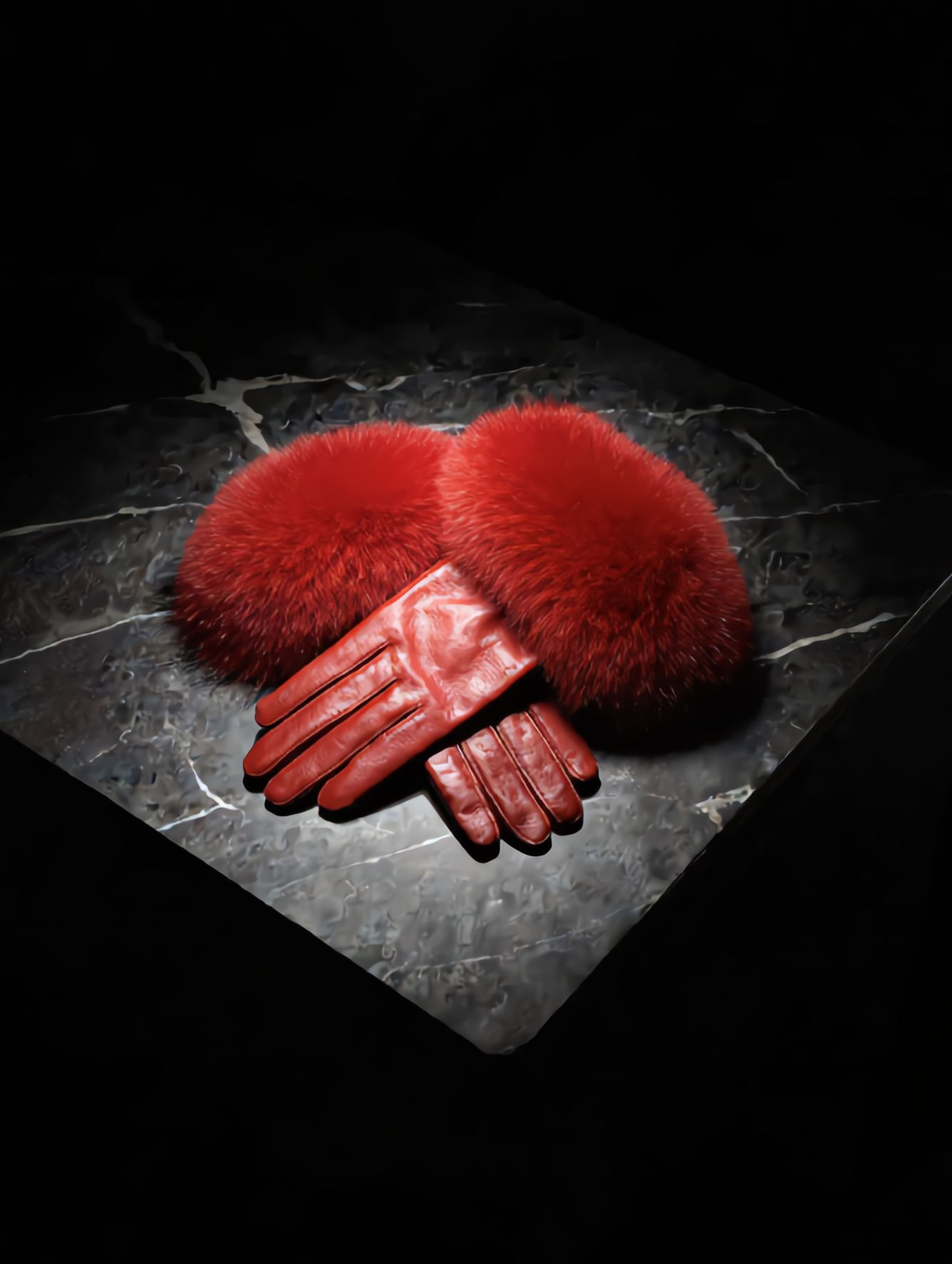 Red fur and leather gloves on a dark stone surface